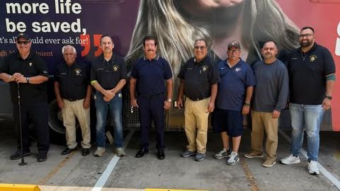 Brother Knights of Council 10562 in front of a blood donor bus